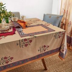 the table is set with place mats and napkins on it, along with other items