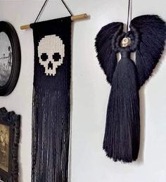 two skulls hanging on the wall next to pictures and an angel's wing decoration