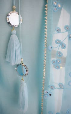 two tassels hanging from the side of a curtain with beads and pearls on it