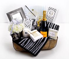 a gift basket filled with champagne, wine and other personal care items on a table