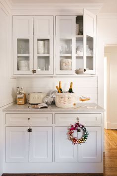 a kitchen with white cabinets and christmas decorations