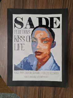 a poster is hanging on the side of a wooden wall that reads sade periodis kiss of life