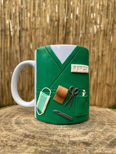 a green mug with scissors and other items on it