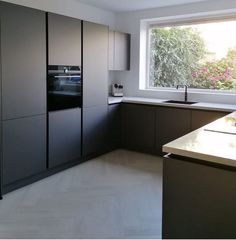 a kitchen with an oven, sink and counter top next to a large open window