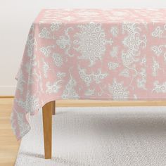 a pink and white table cloth on top of a wooden bench