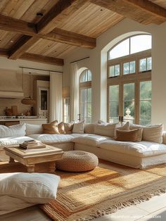 a living room filled with lots of white furniture and large windows in the wall behind it