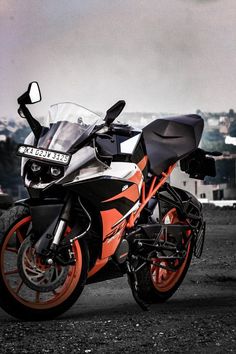 an orange and black motorcycle is parked on the street