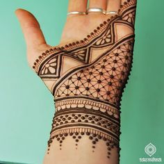 a woman's hand with henna tattoos on it