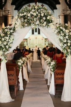 the wedding arch is decorated with white flowers