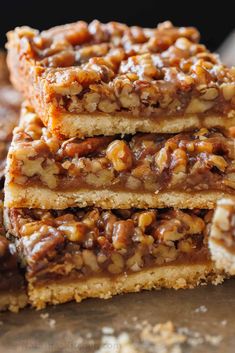 three pieces of pecan bars stacked on top of each other with nuts in the middle