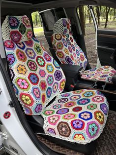 the interior of a car with colorful crocheted seat covers on it's back