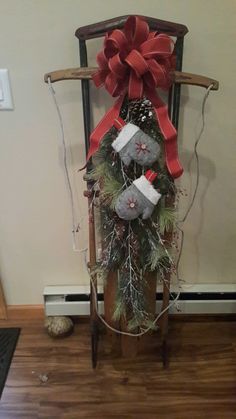 a rocking chair decorated for christmas with presents tied to the sleigh and ribbon