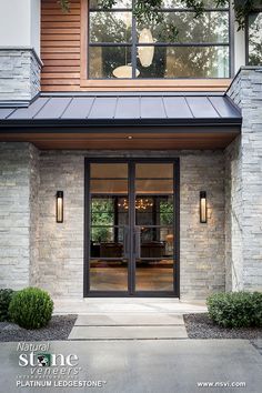 the front entrance to a modern home with glass doors