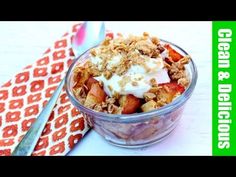 a bowl filled with fruit and yogurt on top of a table next to a spoon