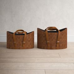 two brown baskets sitting on top of a wooden floor