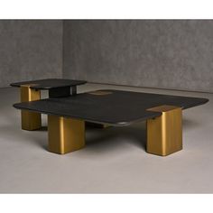 two black tables with gold legs in an empty room