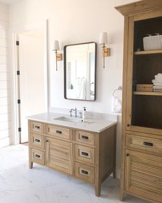 a bathroom with two sinks, cabinets and a large mirror on the wall above it