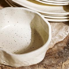 a stack of white plates sitting on top of a wooden table next to each other