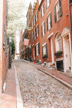 an empty cobblestone street lined with brick buildings