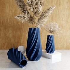 three blue vases with dried plants in them