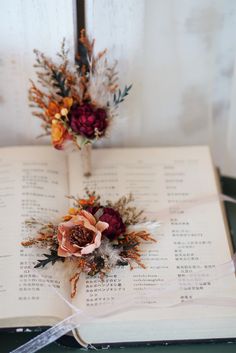 two flowers are placed on top of an open book