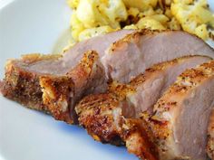 some meat and potatoes on a white plate