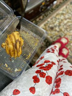 a plastic container filled with food on top of a table next to a pair of leggings