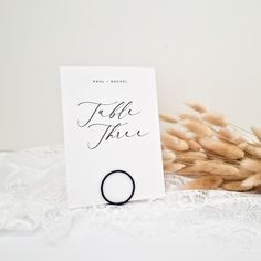 a wedding ring sits next to a card with the word tell it like on it