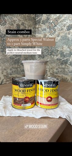 two cans of wood stain sitting on top of a wooden table