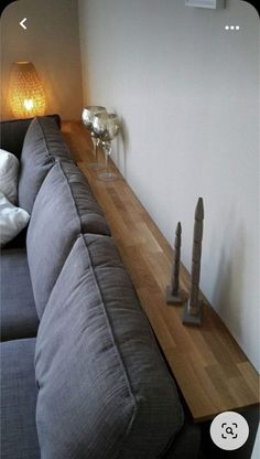 a couch sitting on top of a wooden floor next to a wall with two candles