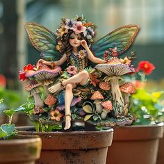 a fairy figurine sitting on top of a potted plant