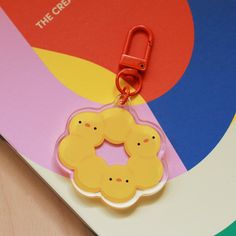 a close up of a keychain on top of a colorful paper with the words the crew