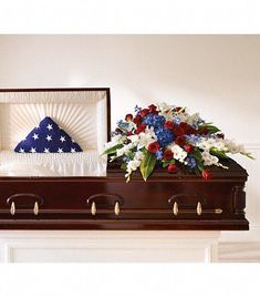 a casket with flowers and an american flag pillow