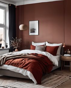 a bedroom with red walls and white bedding