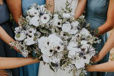 the bridesmaids are holding their bouquets with white and blue flowers on them