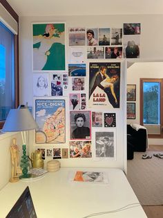 a room with posters on the wall and a lamp