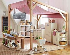 an open kitchen and dining area with chickens on the floor, in front of a pink tent