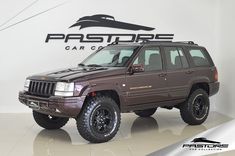 a brown jeep is parked in front of a sign