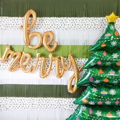 there are balloons that say poo merry next to a christmas tree with gold foil letters