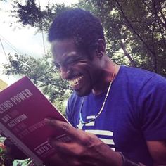 a man smiles while reading a book