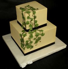 two tiered cake decorated with green leaves and vines