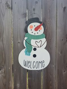 a wooden sign with a snowman on it's face and the words welcome