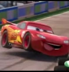 the cars are racing on the track in front of each other and one is wearing an orange shirt