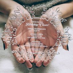 two hands holding an acrylic snowflake with the words holiday cheer written on it