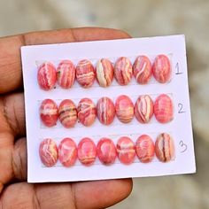 a hand holding several different types of marbles in their palm - held display case