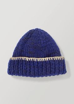 a blue knitted beanie with gold trims on the front and side, against a white background