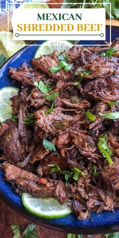 shredded beef on a blue plate with limes and cilantro