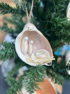 an ornament hanging from a christmas tree decorated with shells and seashells