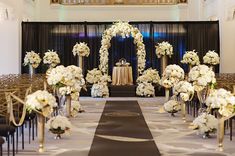 a wedding ceremony setup with white flowers and gold chairs