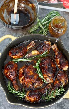 chicken in a skillet with rosemary garnish and sauces on the side